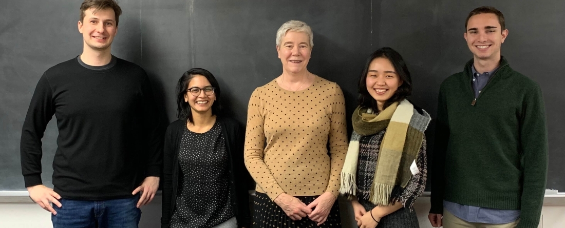 Five students/faculty in front of chalkboard