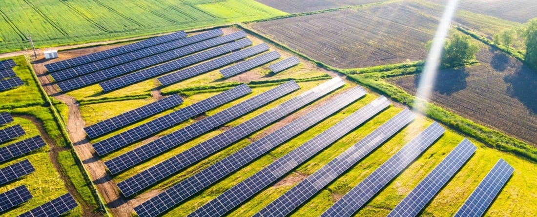 Aerial drone view of solar energy farm in fields. 